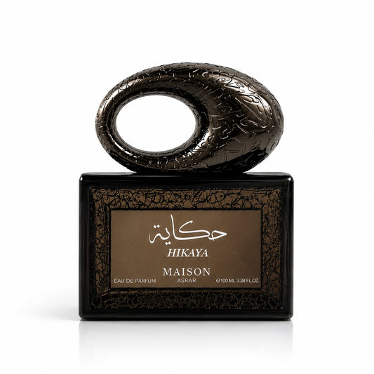 Noor Fragrances Maison Asrar Hikaya Eau de Parfum in a unique, dark metallic sculptural bottle with Arabic calligraphy.