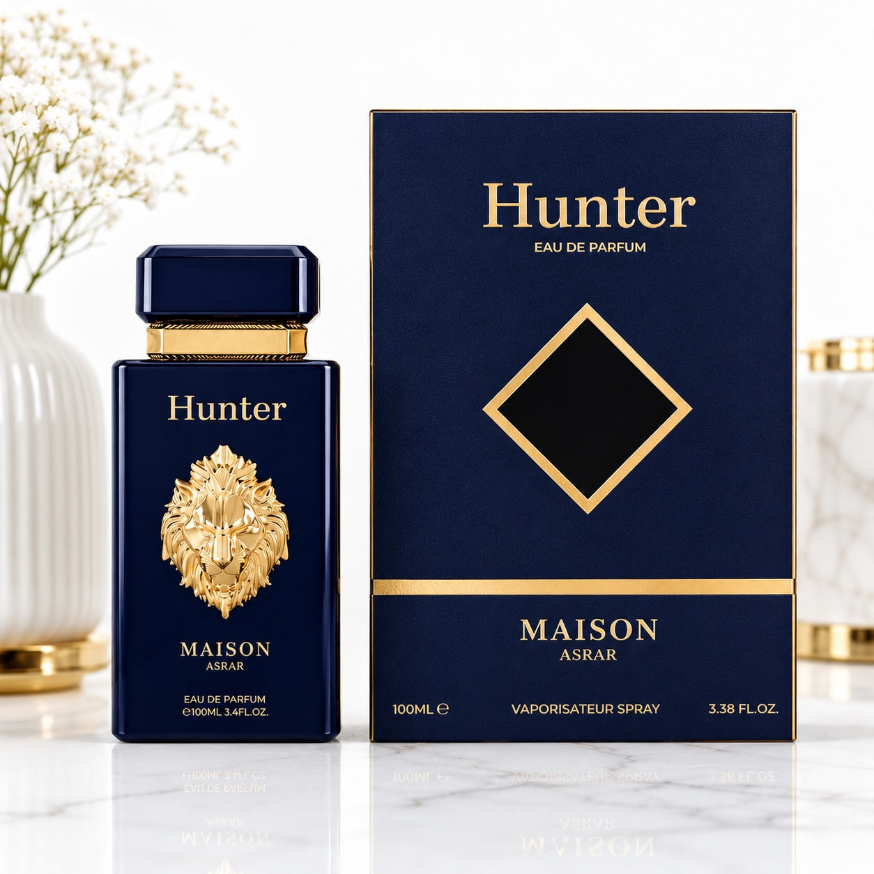 Noor Fragrances Hunter Maison Asrar Eau de Parfum in a navy bottle with a gold lion emblem next to its gift box.