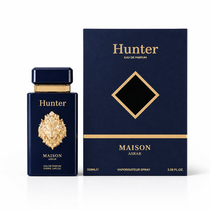 Noor Fragrances Hunter Maison Asrar Eau de Parfum in a navy bottle with a gold lion emblem next to its presentation box.