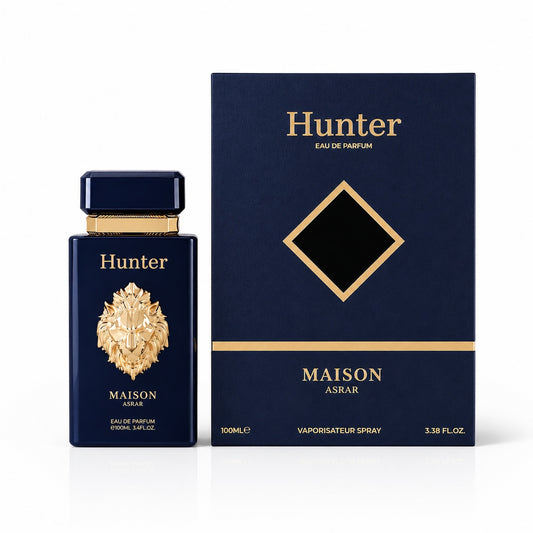 Noor Fragrances Hunter Maison Asrar Eau de Parfum in a navy bottle with a gold lion emblem next to its presentation box.