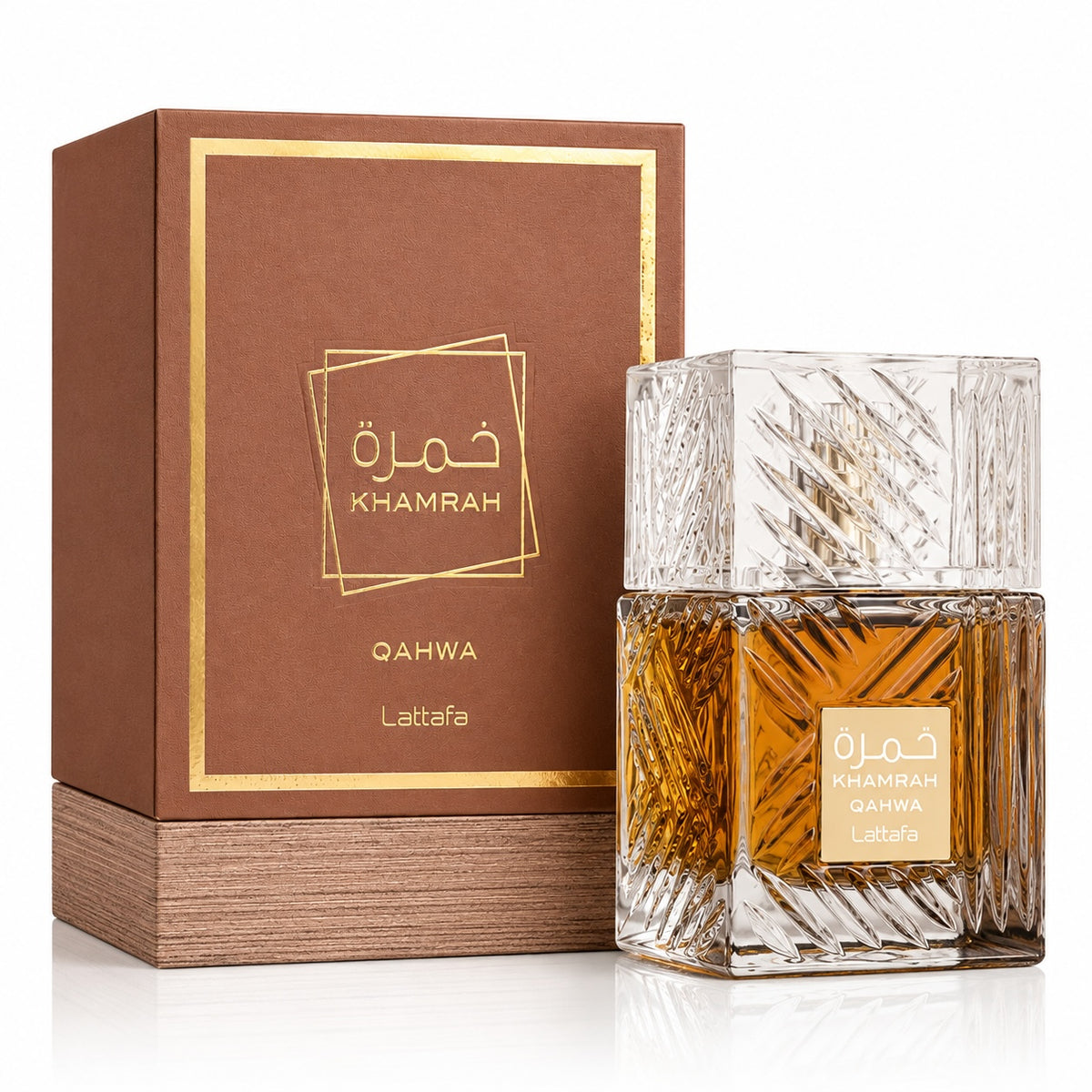 Noor Fragrances Lattafa Khamrah Qahwa eau de parfum in an intricately cut glass bottle next to its brown gift box.