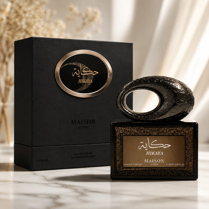 Noor Fragrances Maison Asrar Hikaya Eau de Parfum bottle and black gift box on a marble surface