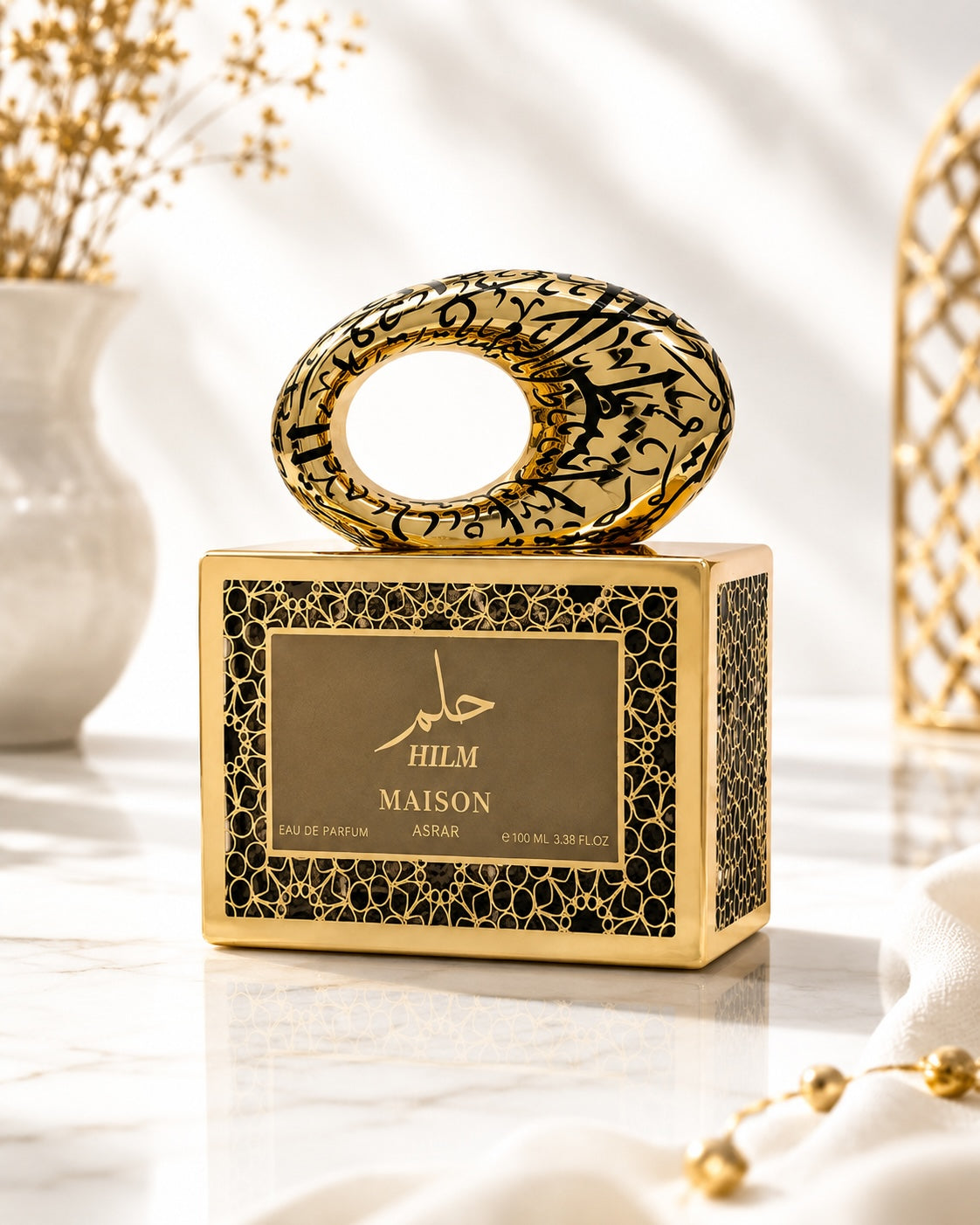Noor Fragrances Maison Asrar Hilm perfume in an ornate gold and black bottle with intricate Arabic calligraphy.