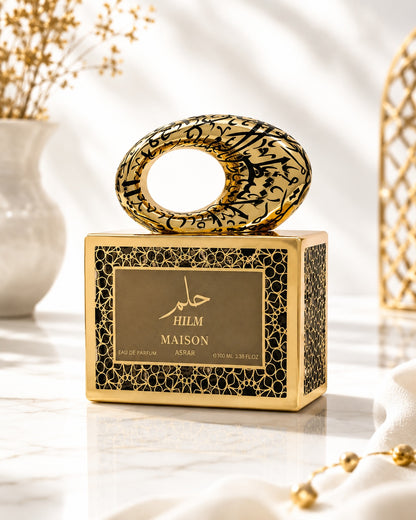Noor Fragrances Maison Asrar Hilm perfume in an ornate gold and black bottle with intricate Arabic calligraphy.