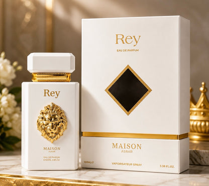 Noor Fragrances MAISON ASRAR Rey Eau De Parfum bottle and white box with gold lion emblem on a marble surface.